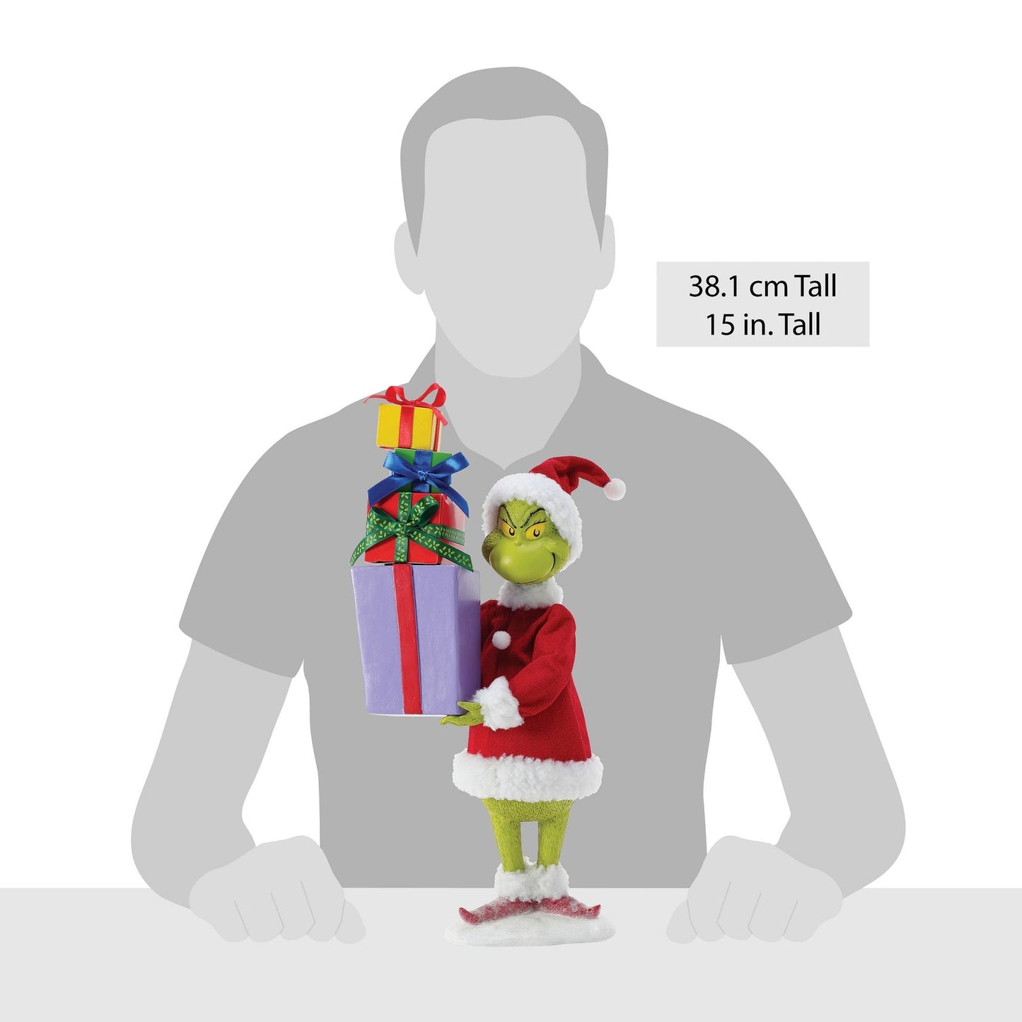 Grinch figurine carrying a stack of gifts shown against a human silhouette for scale, 38.1 cm / 15 inches tall