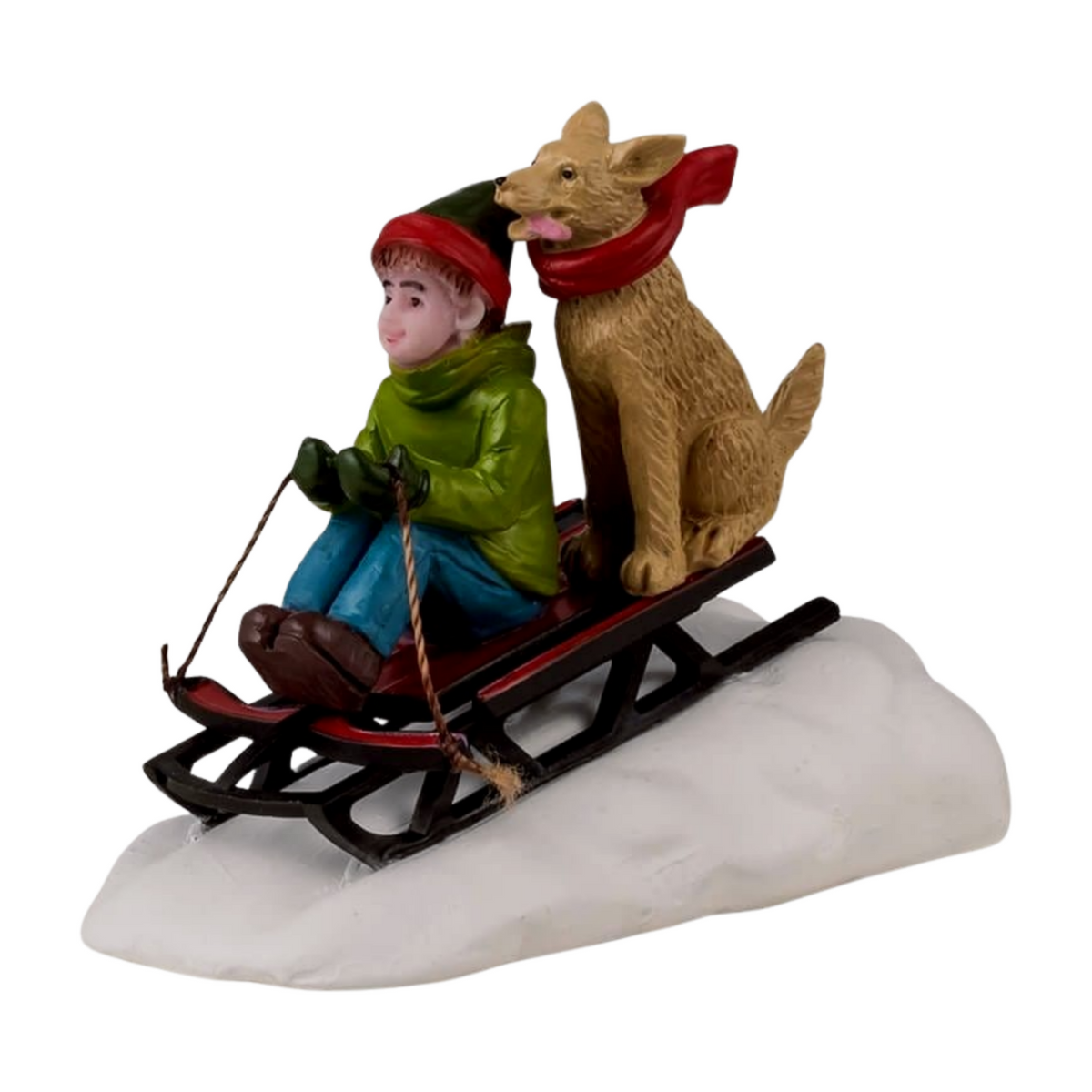 Christmas village figurine of a boy in a green coat sledding downhill with a large brown dog wearing a red scarf behind him