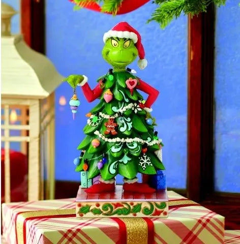 Jim Shore Grinch dressed-as-a-Christmas-tree figurine styled on a gift box in a festive holiday scene