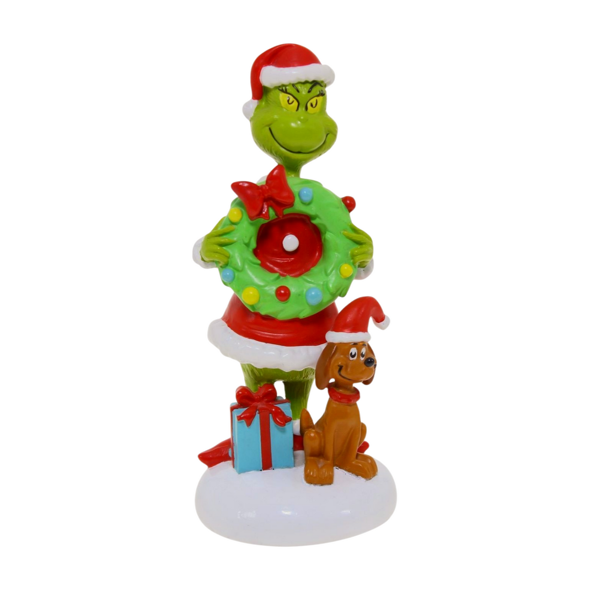 Grinch figurine in a Santa outfit holding a wreath, standing beside a dog in a Santa hat with a present on a snowy base