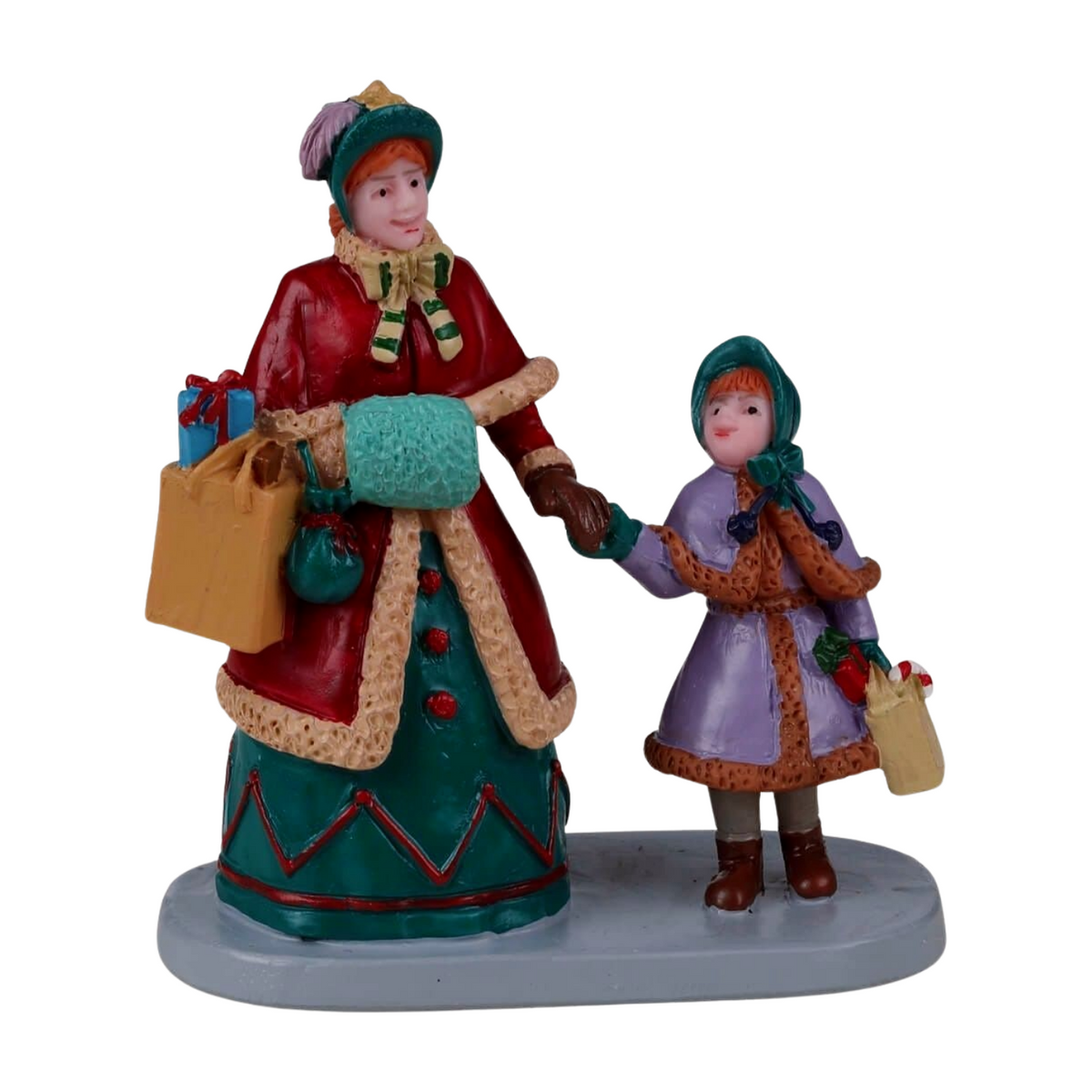Christmas village figurine of a woman in red and teal winter coat holding a girl's hand, both carrying Christmas gifts and bags