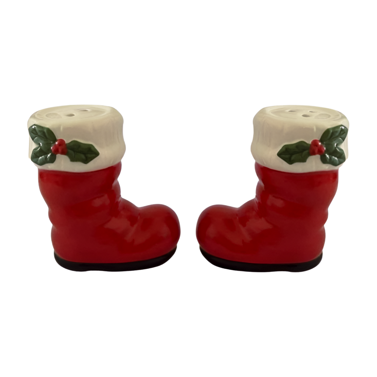 Red ceramic Santa boot salt and pepper shakers with white trim and holly leaf accents