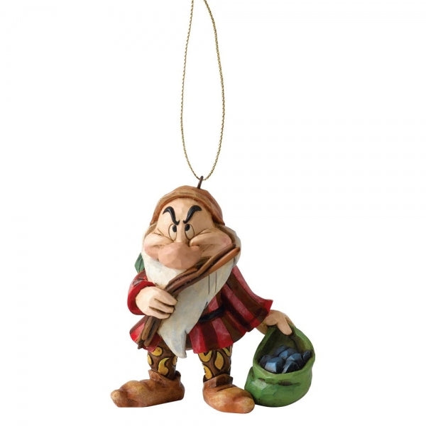 Grumpy dwarf hanging ornament with folk art detailing, arms crossed, holding a sack of coal, in a red cape and patterned trousers