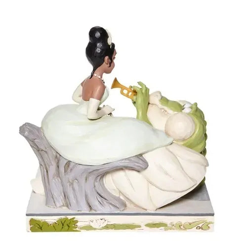Tiana and Louis the alligator figurine, rear view, Louis playing trumpet beside Tiana in white gown, on lily pad base