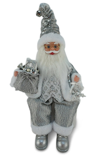 Sitting Santa Claus wearing silver with sequin accents, holding a sack of presents in one hand and a snowflake decoration in the other