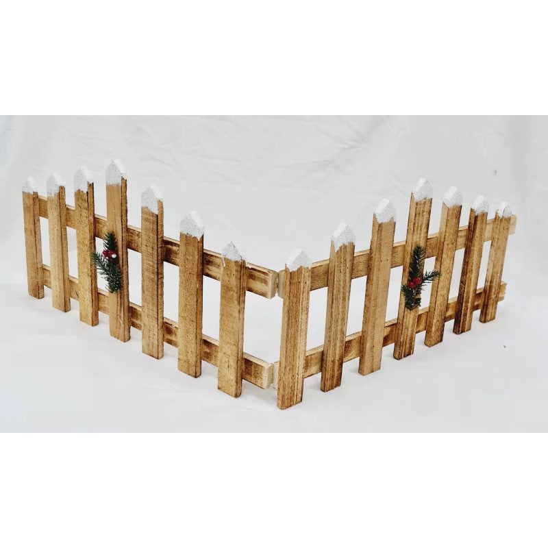 Wooden Christmas fence with snow-tipped tops and small greenery sprigs with red berries