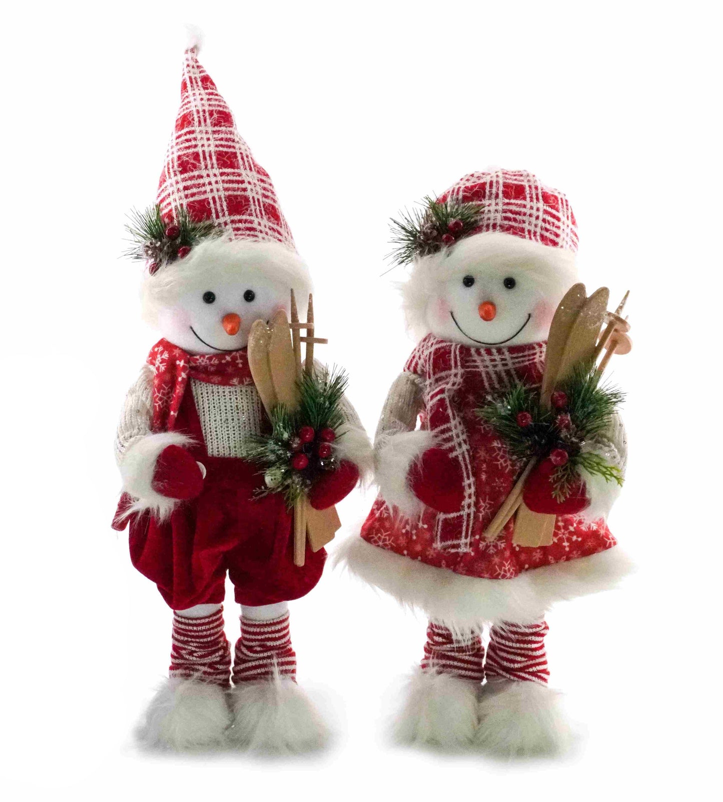 Snowman boy figurine wearing red shorts and hat, holding wooden skis and greenery