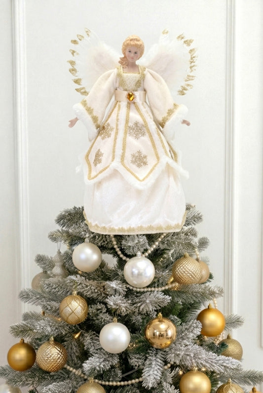 Angel tree topper in cream and gold dress with feathered wings on a decorated Christmas tree