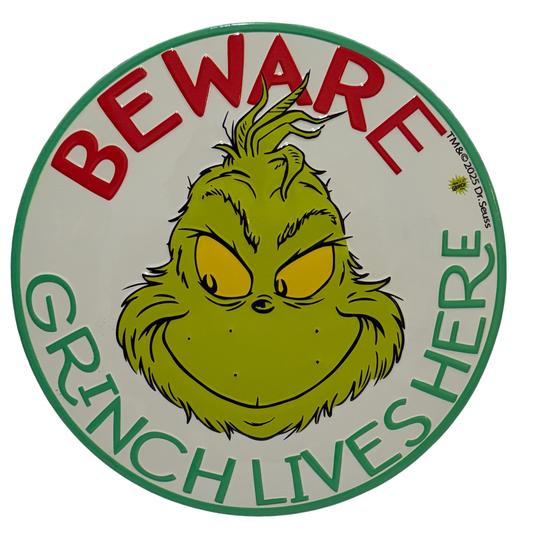 Round sign with the Grinch’s face and red and green text reading “Beware Grinch Lives Here”