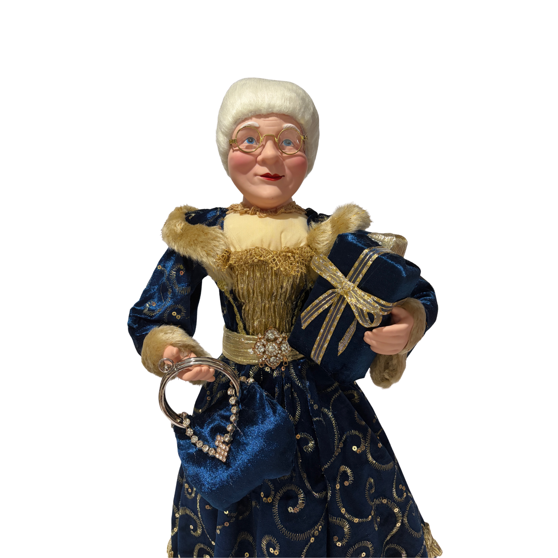 Mrs Claus wearing a blue dress with gold accents, holding two presents in one hand and a blue handbag in the other