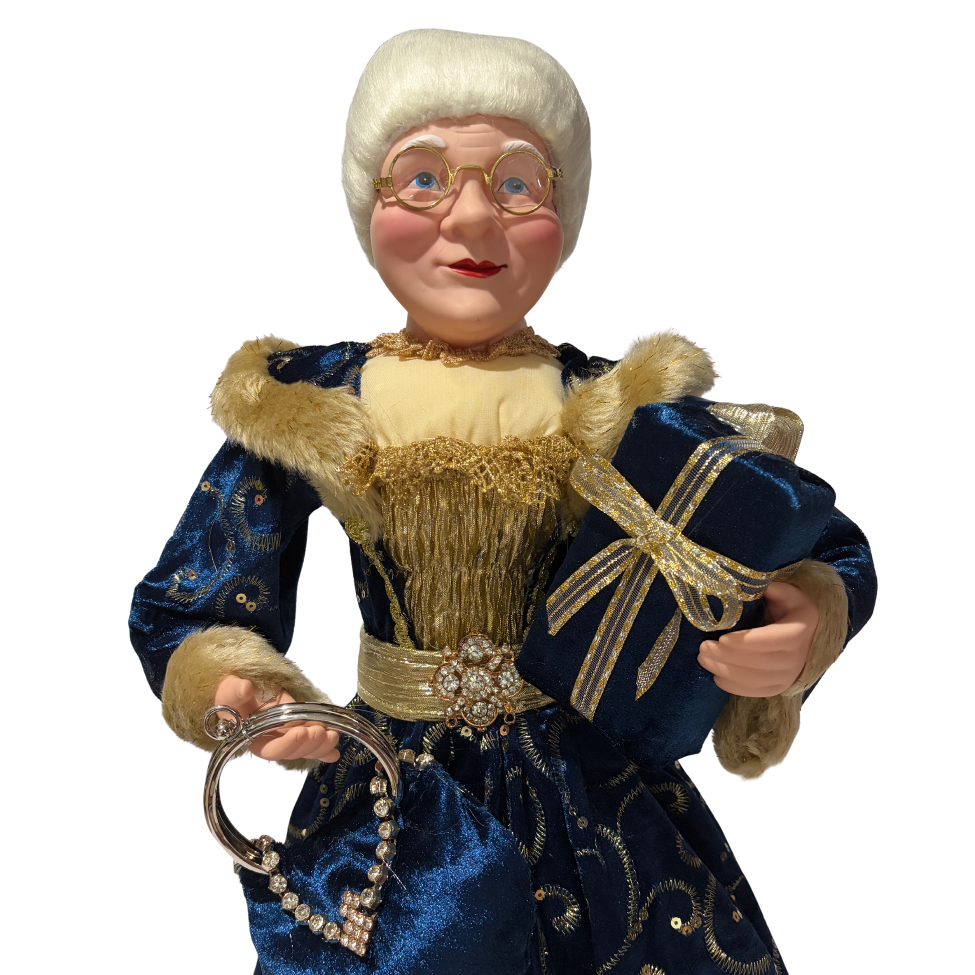  Mrs Claus wearing a blue dress with gold accents, holding two presents in one hand and a blue handbag in the other