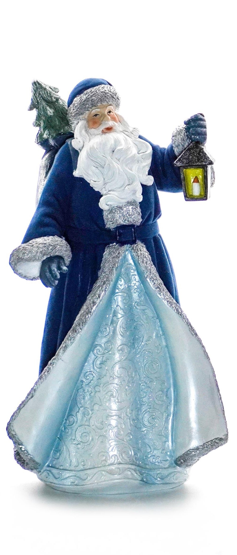 Santa figurine in a blue and silver coat holding a lantern with a Christmas tree on his back