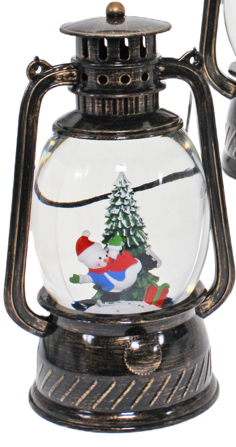 Bronze Christmas lantern snow globe featuring a snowman beside a Christmas tree with swirling glitter.
