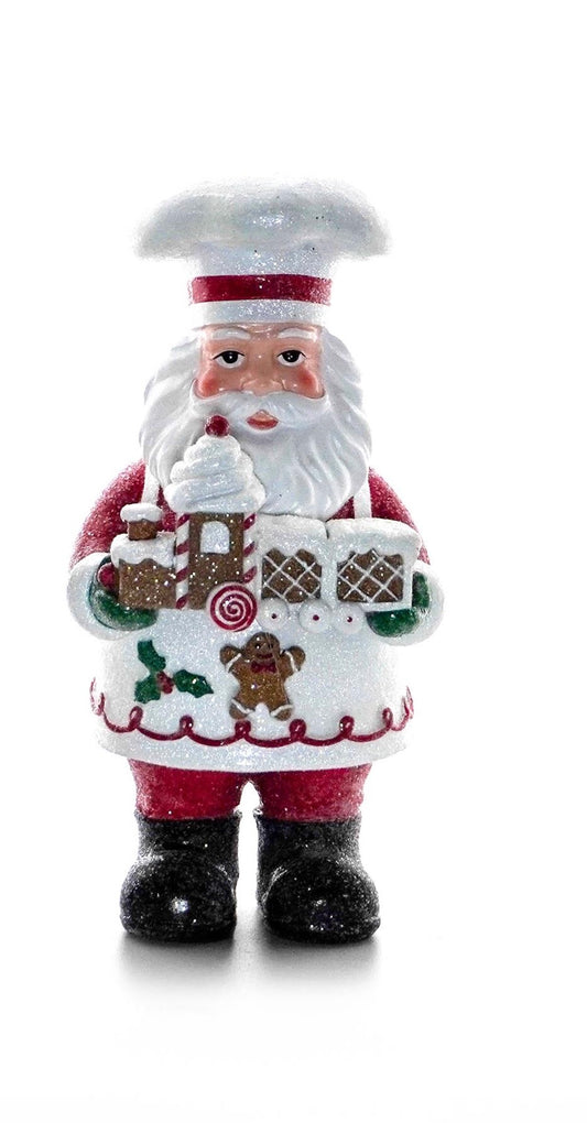 Chef Santa figurine holding a gingerbread train with candy details and glittered baker’s hat