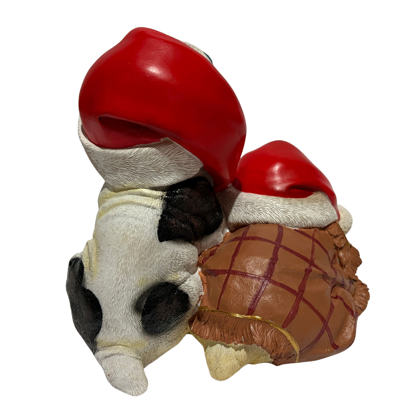 Two bulldogs wearing red Santa hats with colourful jewels, one sitting and one sleeping