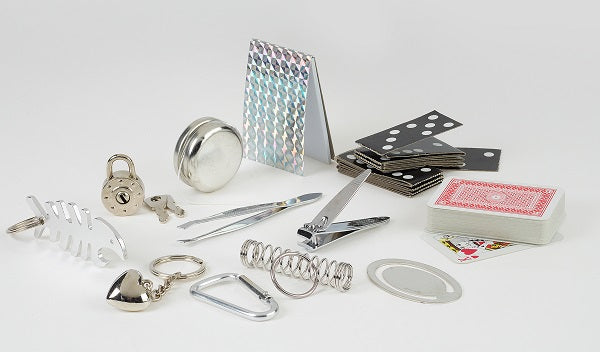 Collection of various small objects including a lock, scissors, and playing cards on a white background