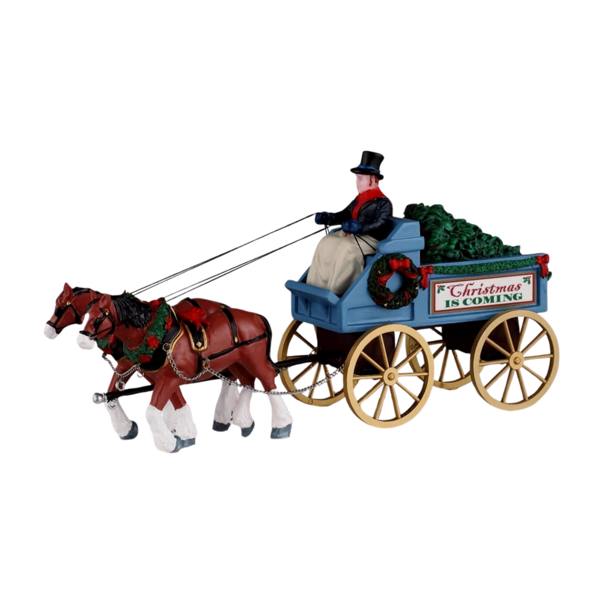 Christmas village figurine of a horse-drawn blue wagon labelled Christmas Is Coming, loaded with trees, driven by a man in a top hat