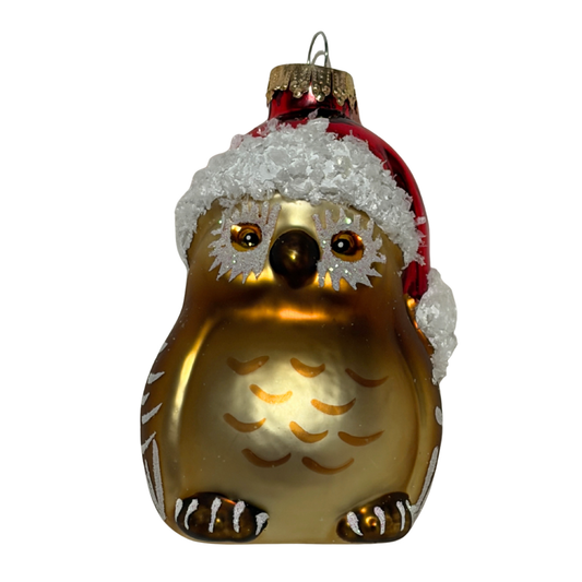 Glass owl ornament wearing a Santa hat on a white background