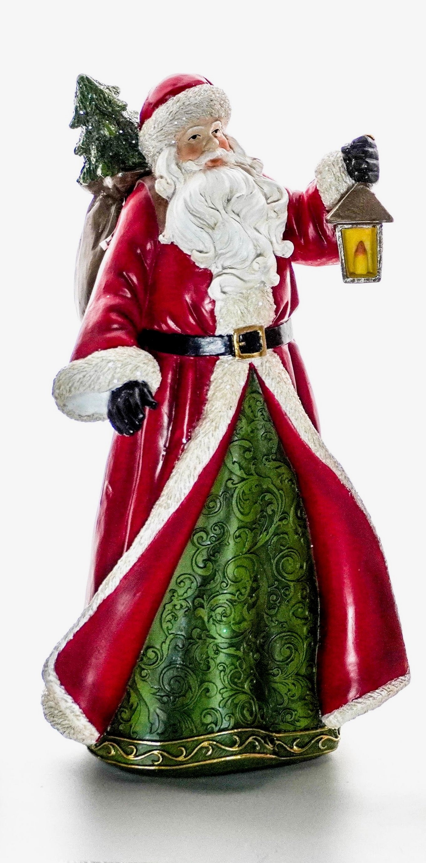 Santa figurine in a red coat and green robe holding a lantern with a Christmas tree in his sack