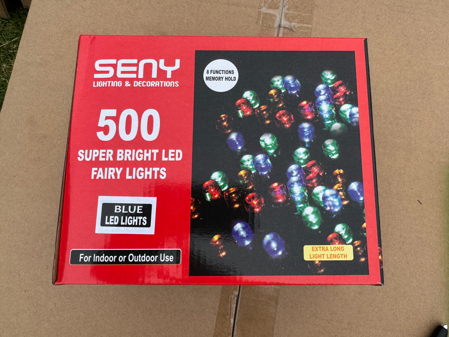 Box of LED fairy lights with colorful lights on a cardboard background