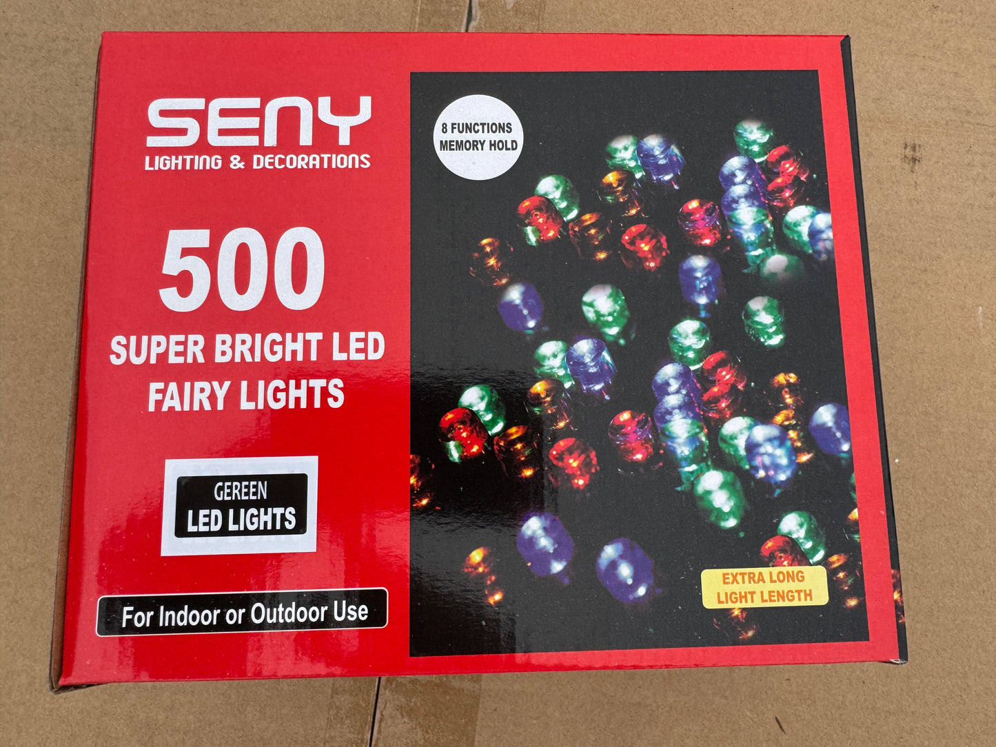 Box of LED fairy lights with colorful lights on a red background