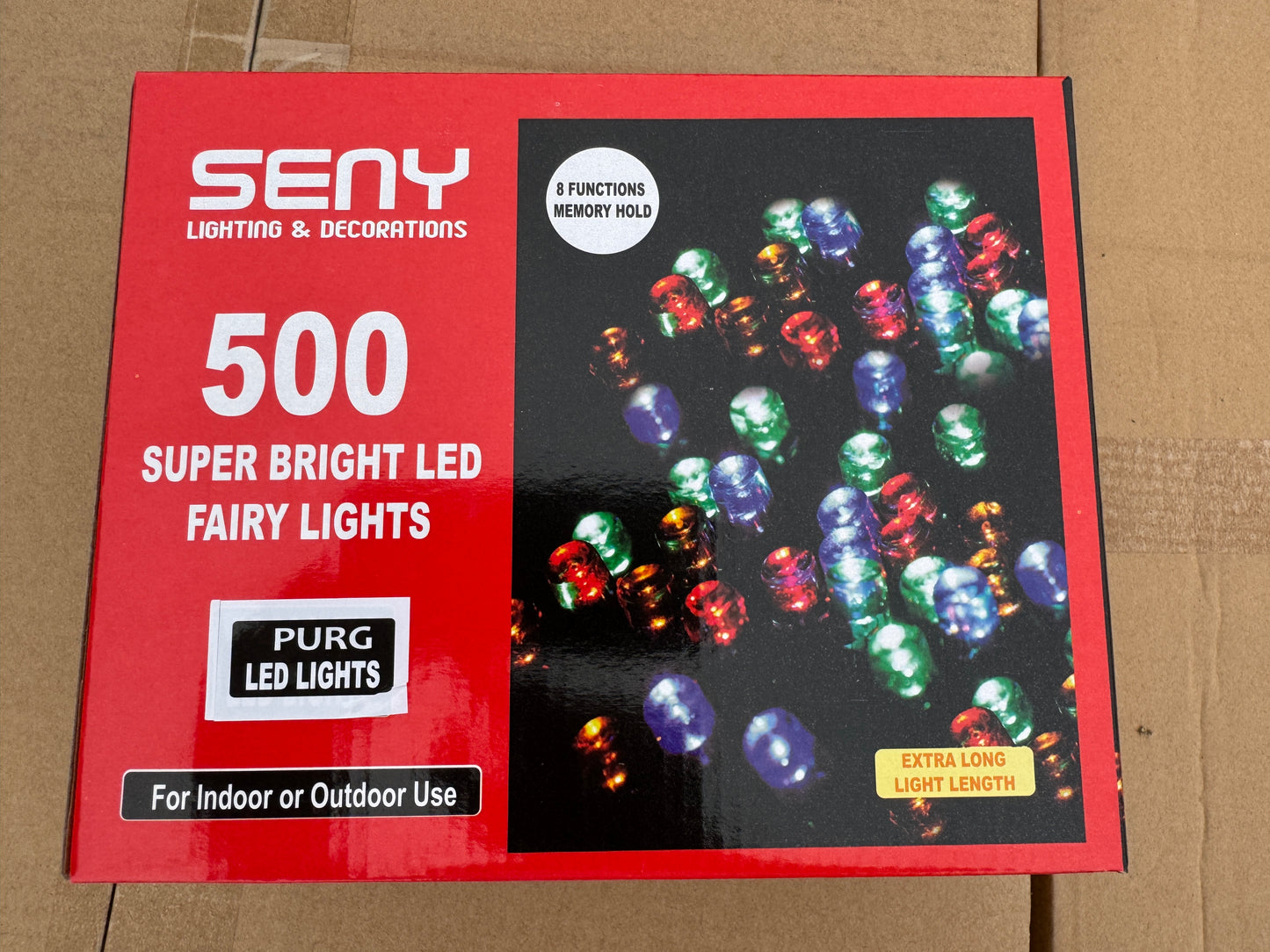 Box of LED fairy lights with colorful lights on a cardboard background
