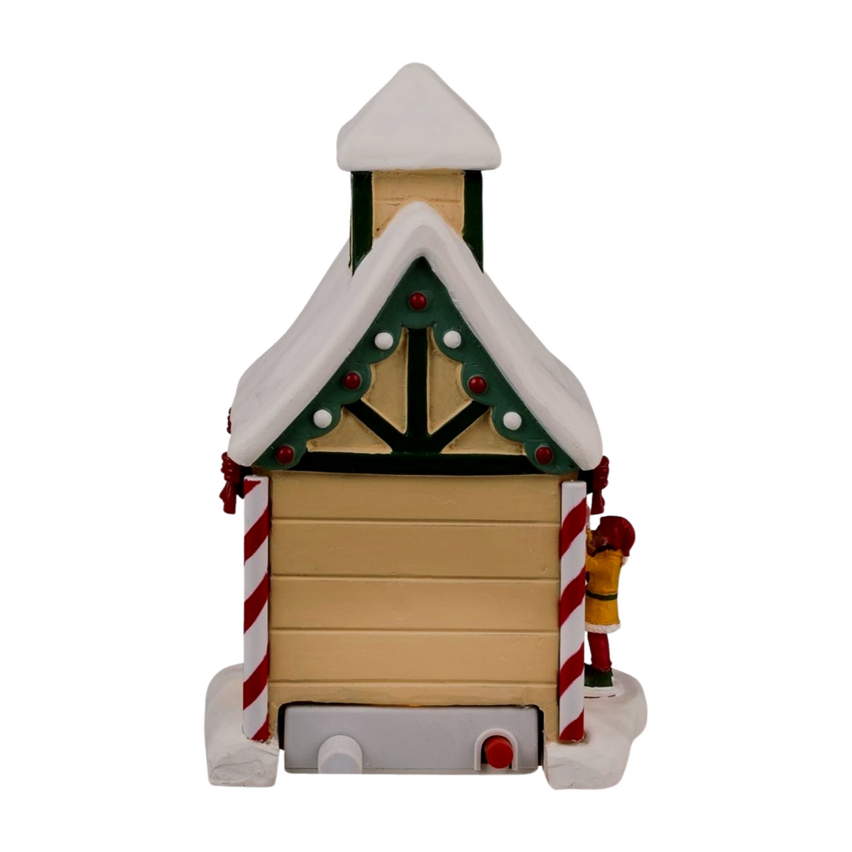 Rear-facing angle of Dancer's reindeer stable Christmas village building showing holly-decorated gable, candy cane columns, and elf figurine