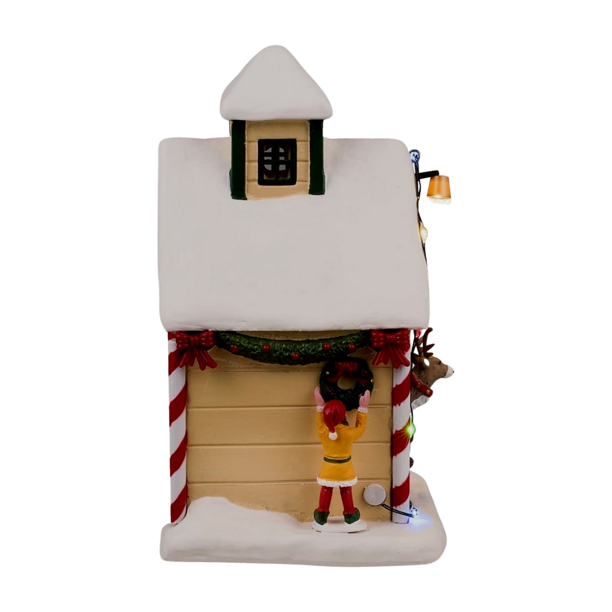 Right view of Dancer's reindeer stable Christmas village building showing snow-covered roof, reindeer peeking out, and candy cane columns 