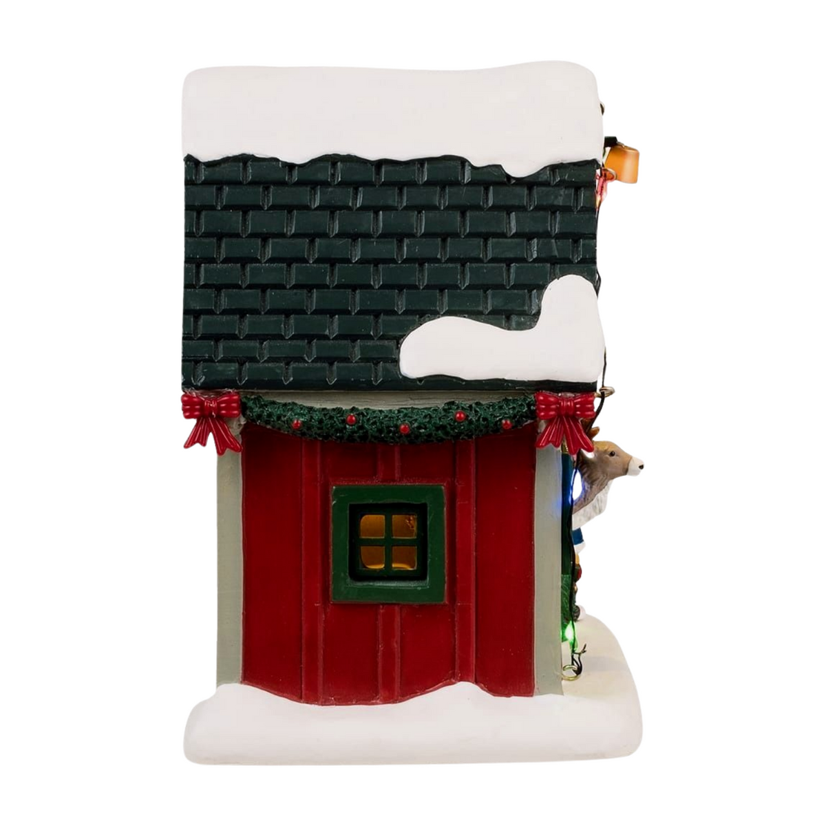 Right view of Lemax Dasher's reindeer stable with dark tiled roof, snow-capped top, garland with red bows, and lit window