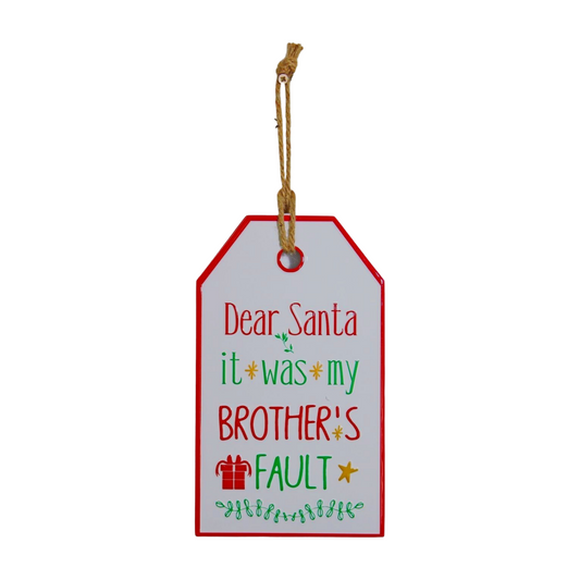 Rectangular Christmas hanging sign shaped like a gift tag with red and green text reading “Dear Santa it was my brother’s fault” and jute string for hanging