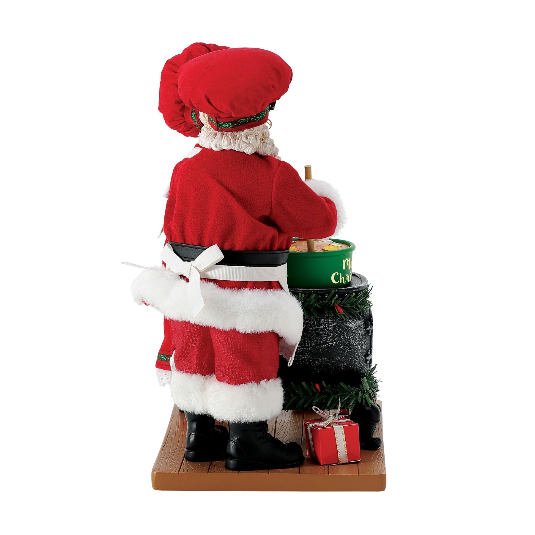 Side view of Santa chef figurine in red outfit and chef's hat, stirring a green "Merry Christmas" pot on a garland-wrapped stove