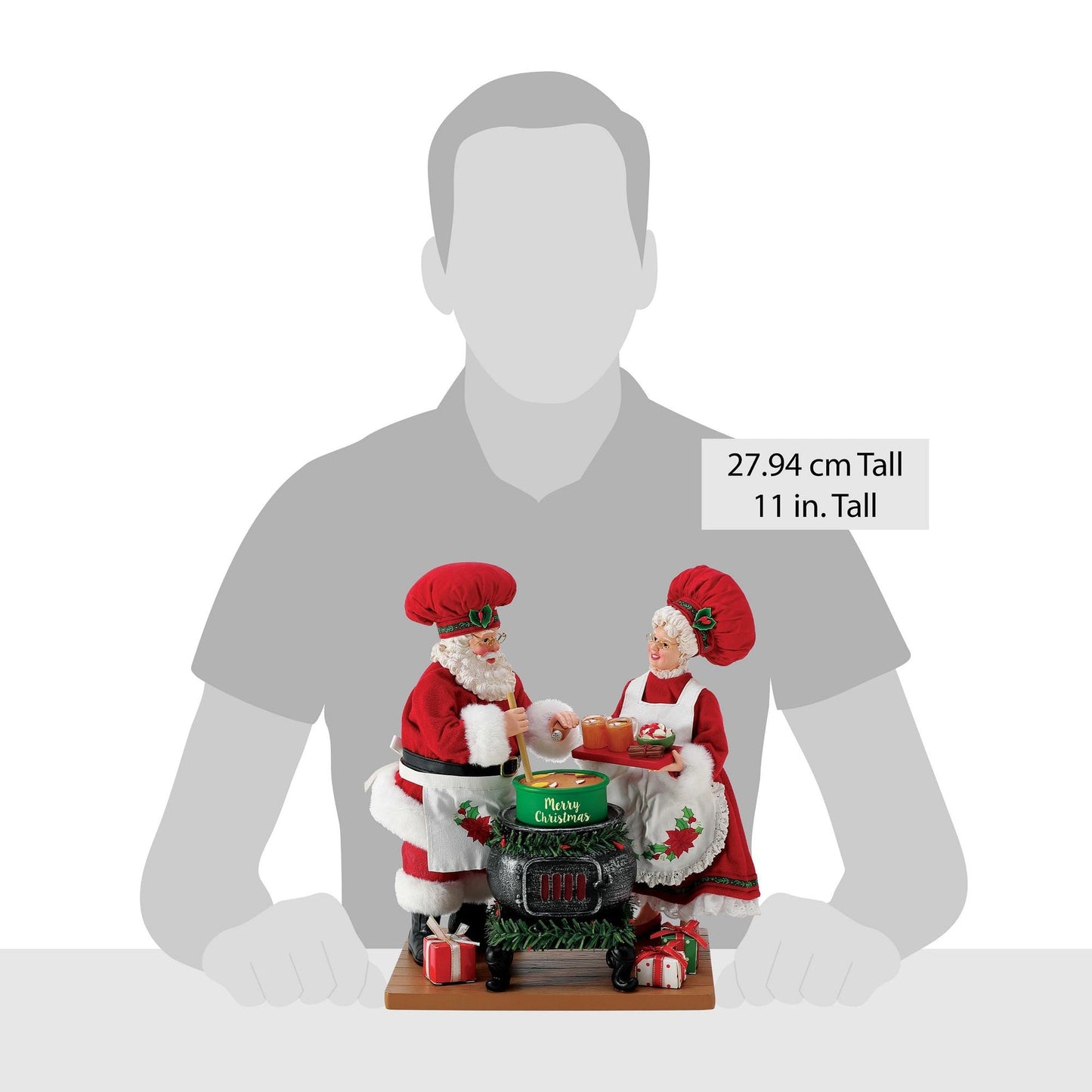 Santa and Mrs. Claus chef figurines shown against a human silhouette for scale, 27.94 cm / 11 inches tall