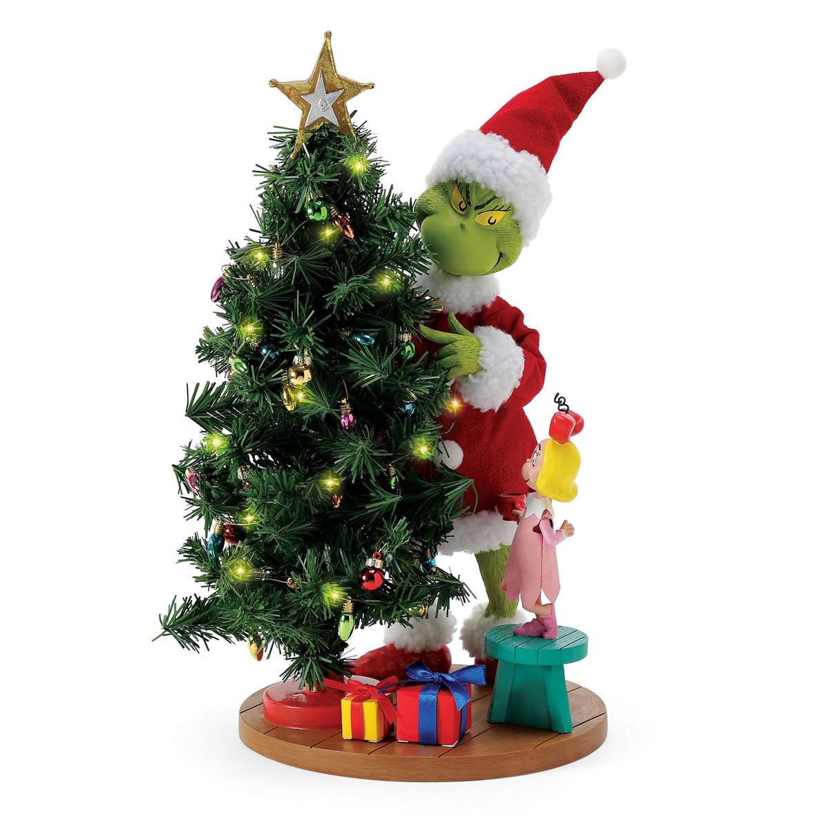 Front view of the Grinch figurine stealing a lit, ornament-decorated Christmas tree while Cindy Lou Who looks on from a small stool