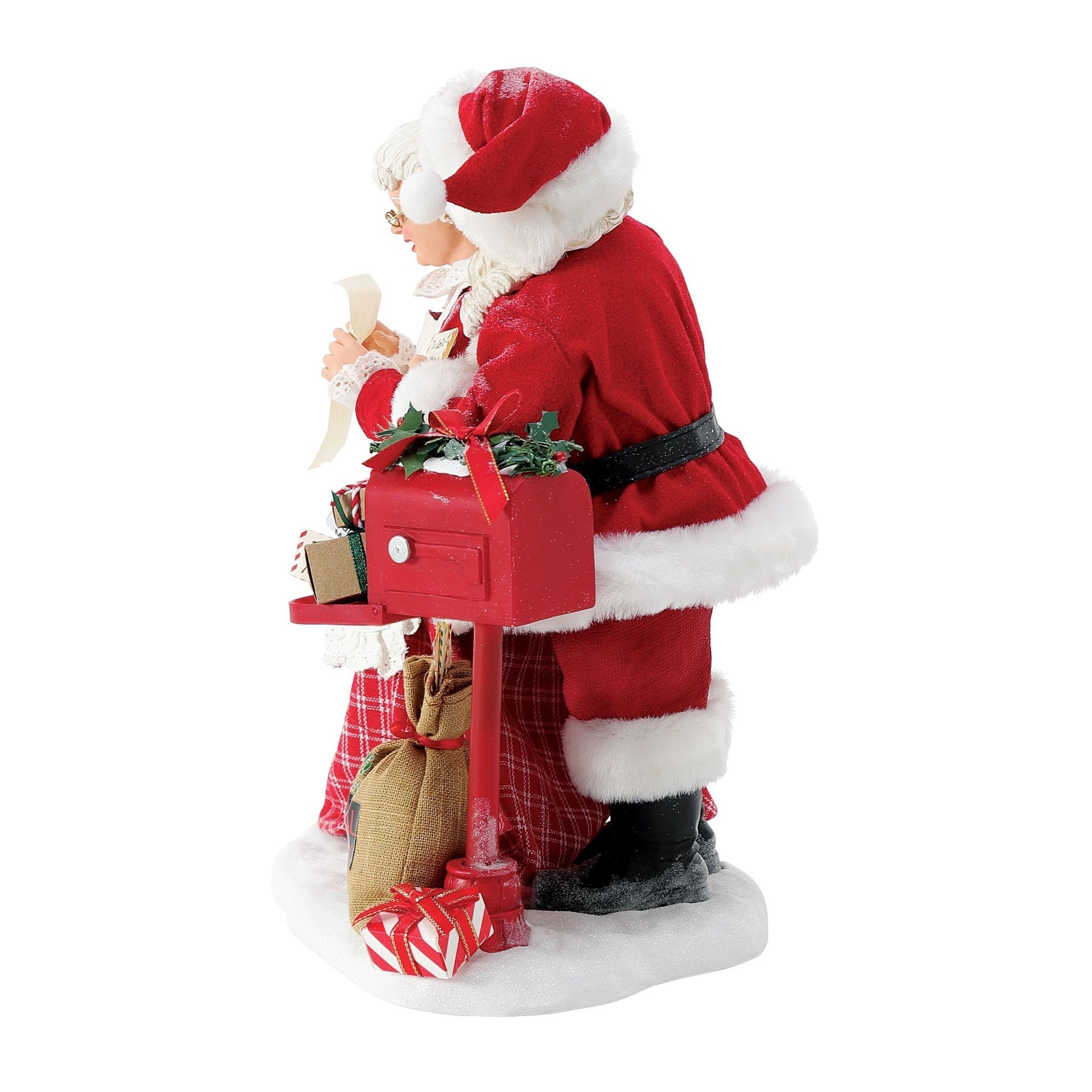 Side view of Santa figurine with his arm around Mrs. Claus as she reads a letter, red plaid skirt and lace apron detail visible
