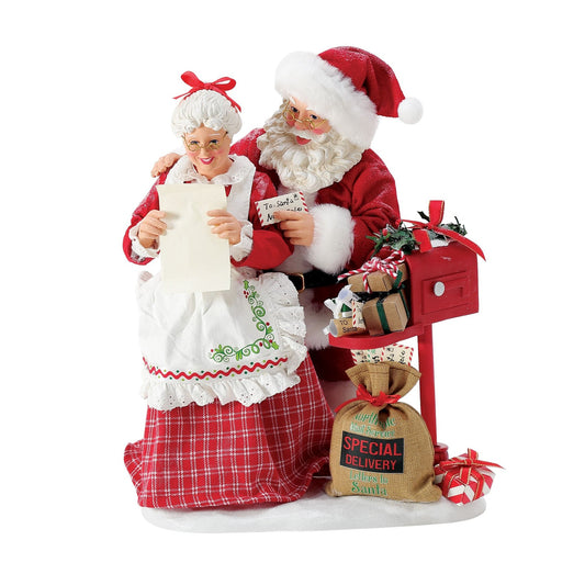 Santa and Mrs. Claus figurines reading a letter together at a red mailbox with a "North Pole Special Delivery – Letters to Santa" sack at their feet 