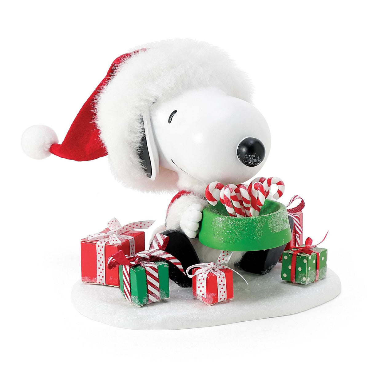 Snoopy figurine dressed as Santa, leaning over a green dog bowl filled with candy canes, surrounded by wrapped red and green gifts