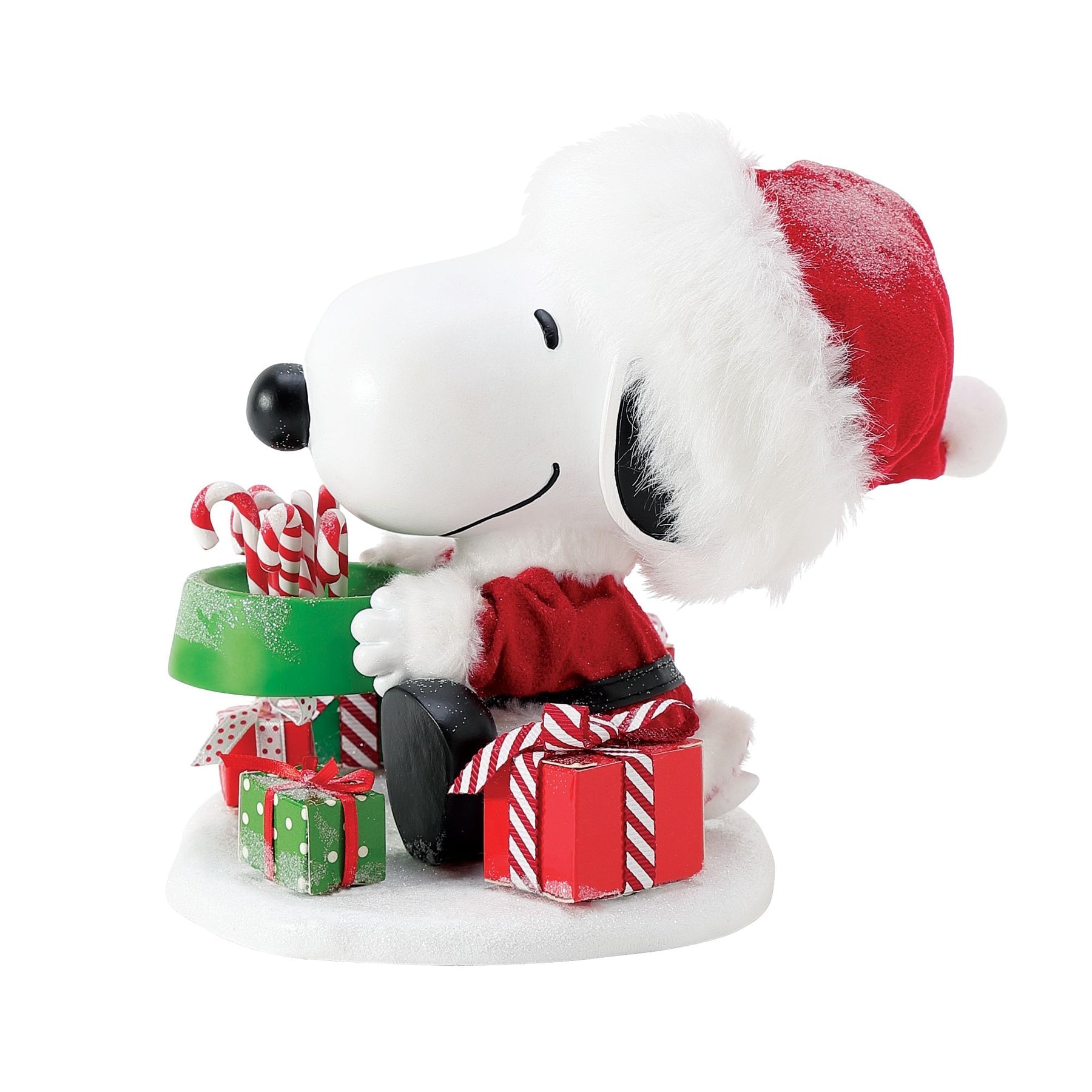 Snoopy figurine in Santa hat, right-side view, holding a green dog bowl filled with candy canes, with wrapped gifts on a snowy base