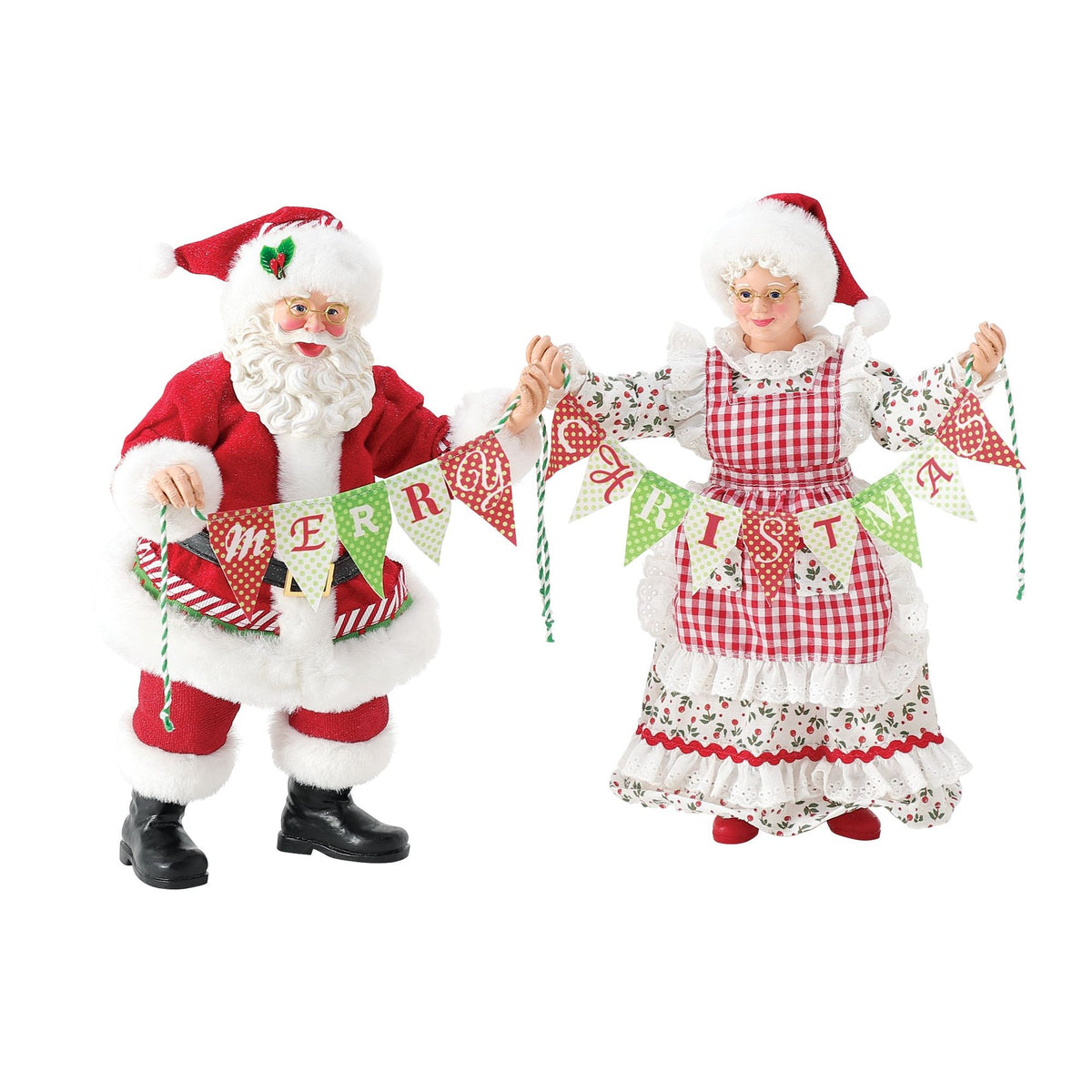 Santa and Mrs. Claus figurines holding a "Merry Christmas" pennant banner; Mrs. Claus in a gingham apron over a holly-print dress 