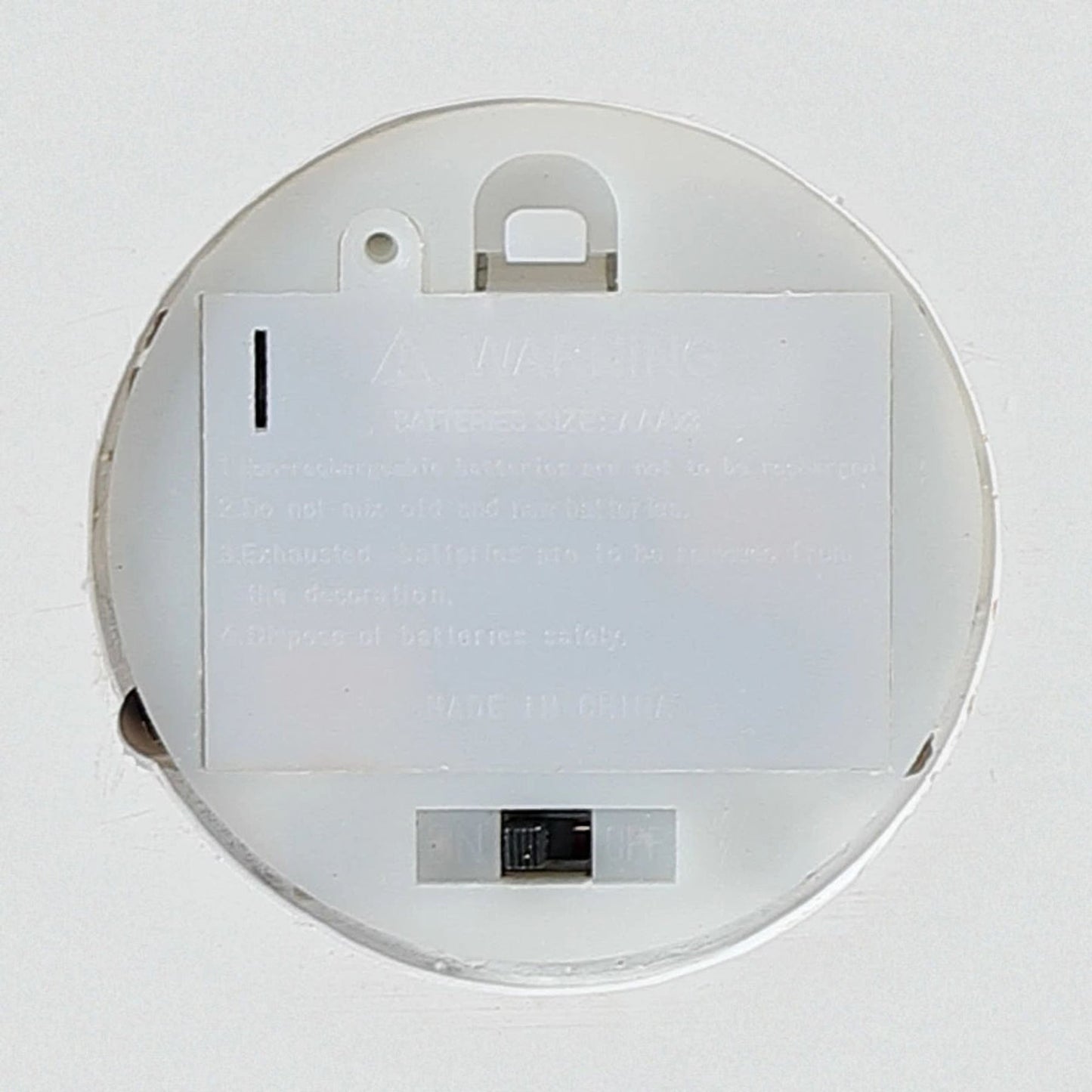 Underside of the fireplace base showing battery compartment and on/off switch for the built-in lights