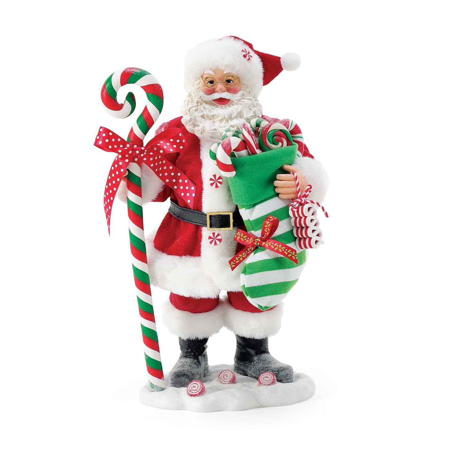Front view of Santa figurine in peppermint-dotted red suit, holding a candy-filled green striped stocking beside a tall striped candy cane staff