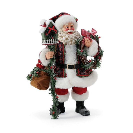 Santa figurine in red plaid coat with white trim, holding a birdhouse pole, greenery wreath with gingham bow, and gift sack