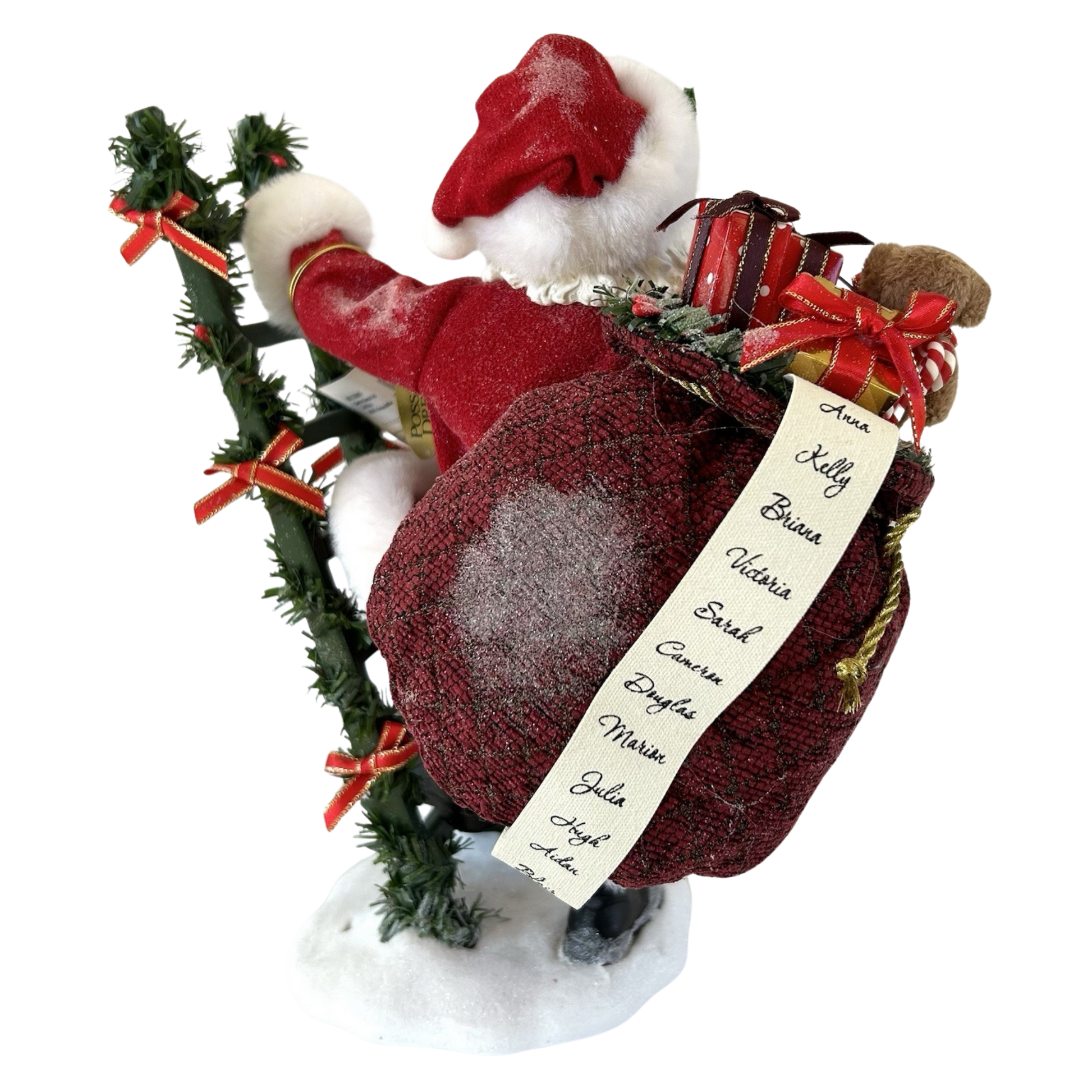 Back view of a Santa figure carrying a gift-filled burgundy sack with a handwritten naughty-and-nice list, beside a garland-wrapped ladder