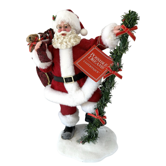Front view of a Possible Dreams Santa figure holding a garland-wrapped ladder and a burgundy gift sack with teddy bear, on a snow base