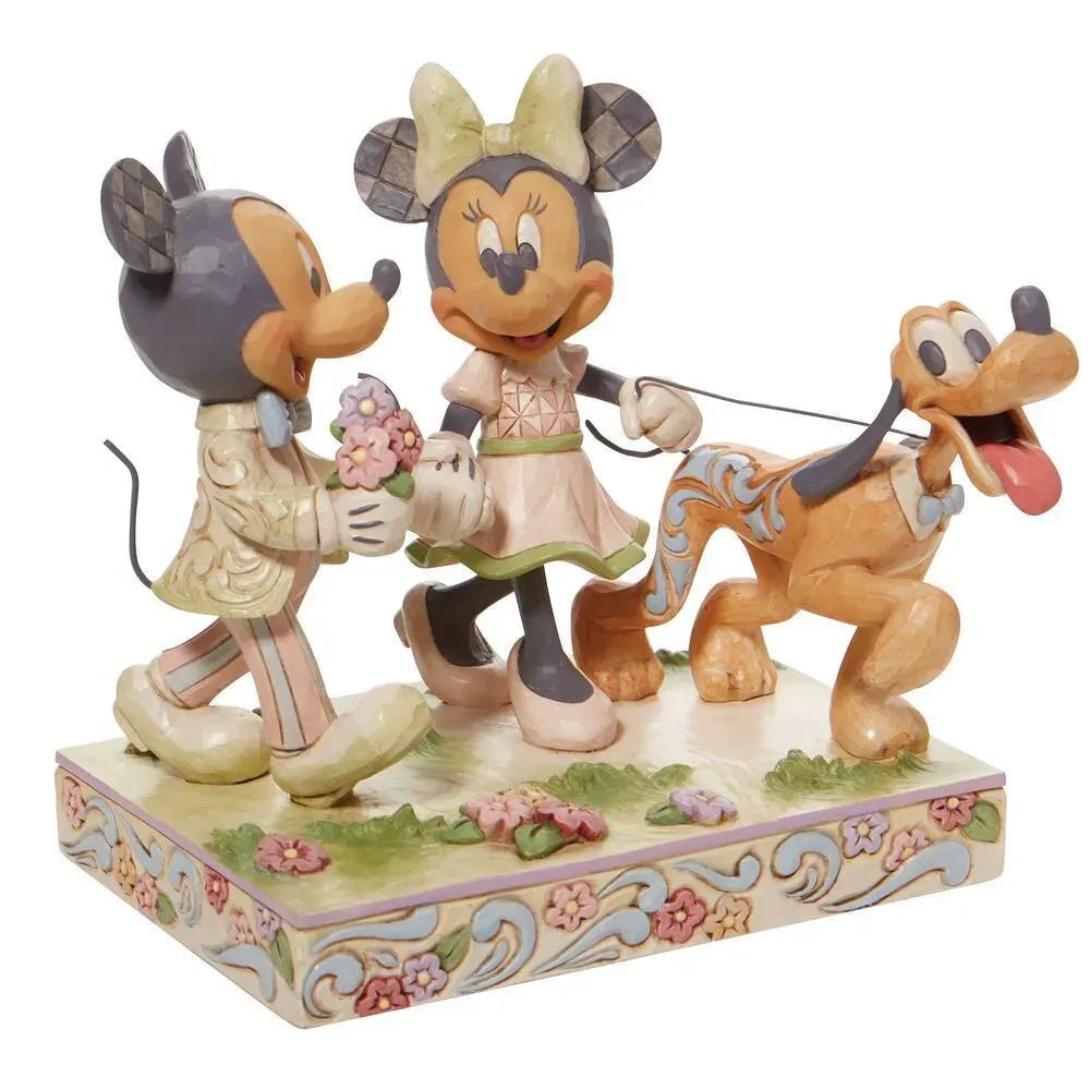 Disney Traditions figurine of Mickey and Minnie Mouse holding hands with Pluto, in pastel spring colours on a floral base