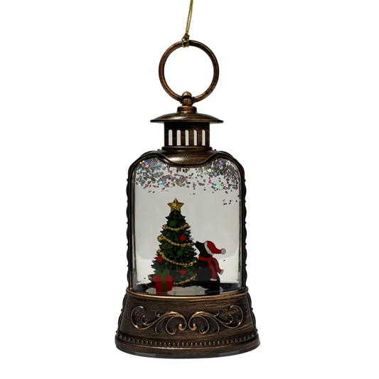 Mini lantern with a dog in a Santa hat looking at a decorated Christmas tree and swirling glitter