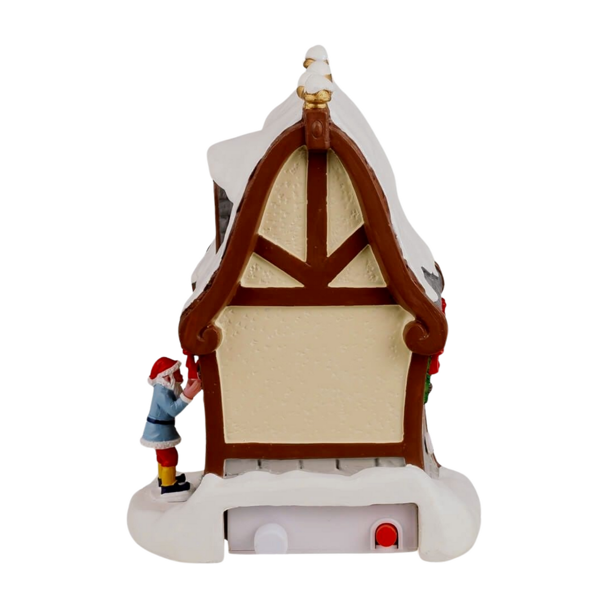 Rear view of Donner's reindeer stable Christmas village building with arched timber-framed gable, snow-covered roof, and small elf figurine