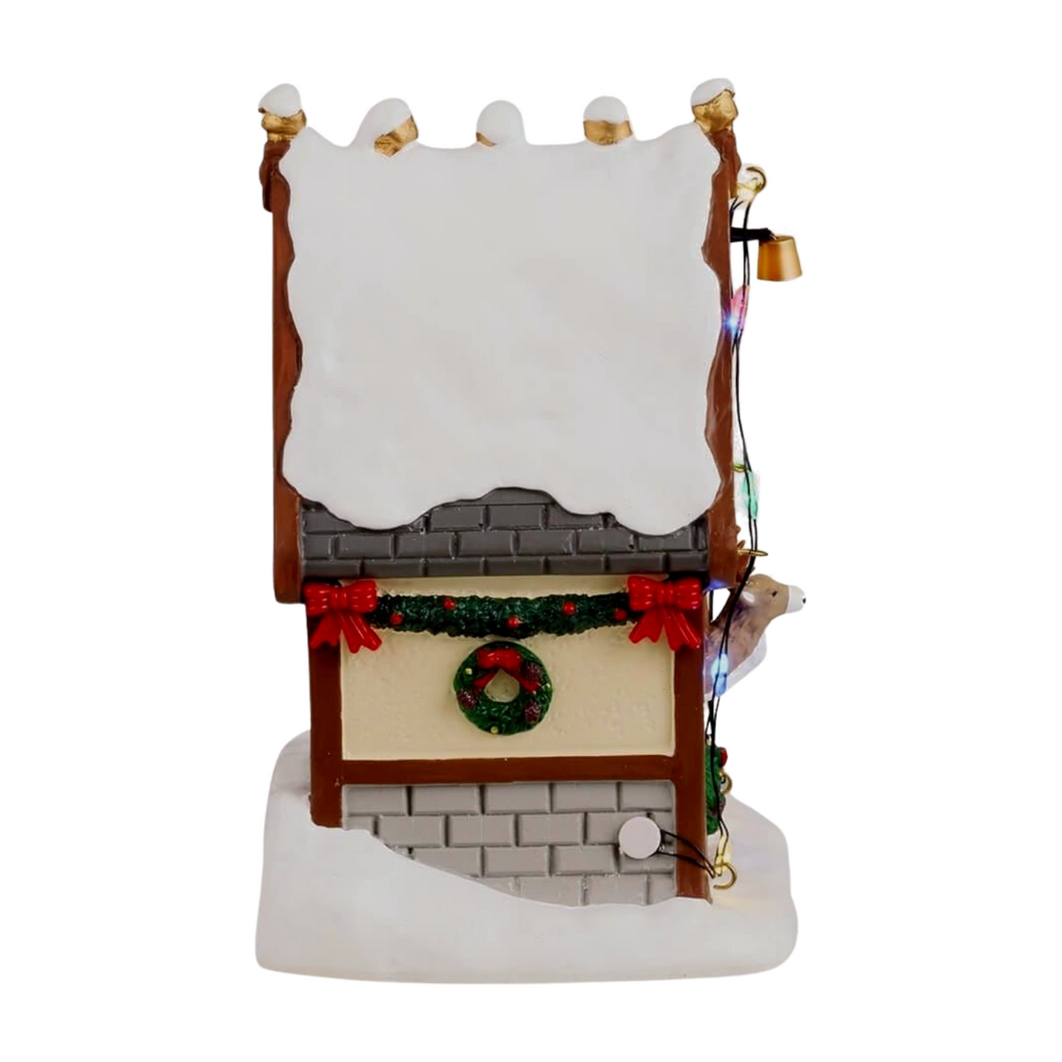 Right view of Donner's reindeer stable village building with Donner sign, lit doorway with reindeer, multicoloured lights, and elf figurine