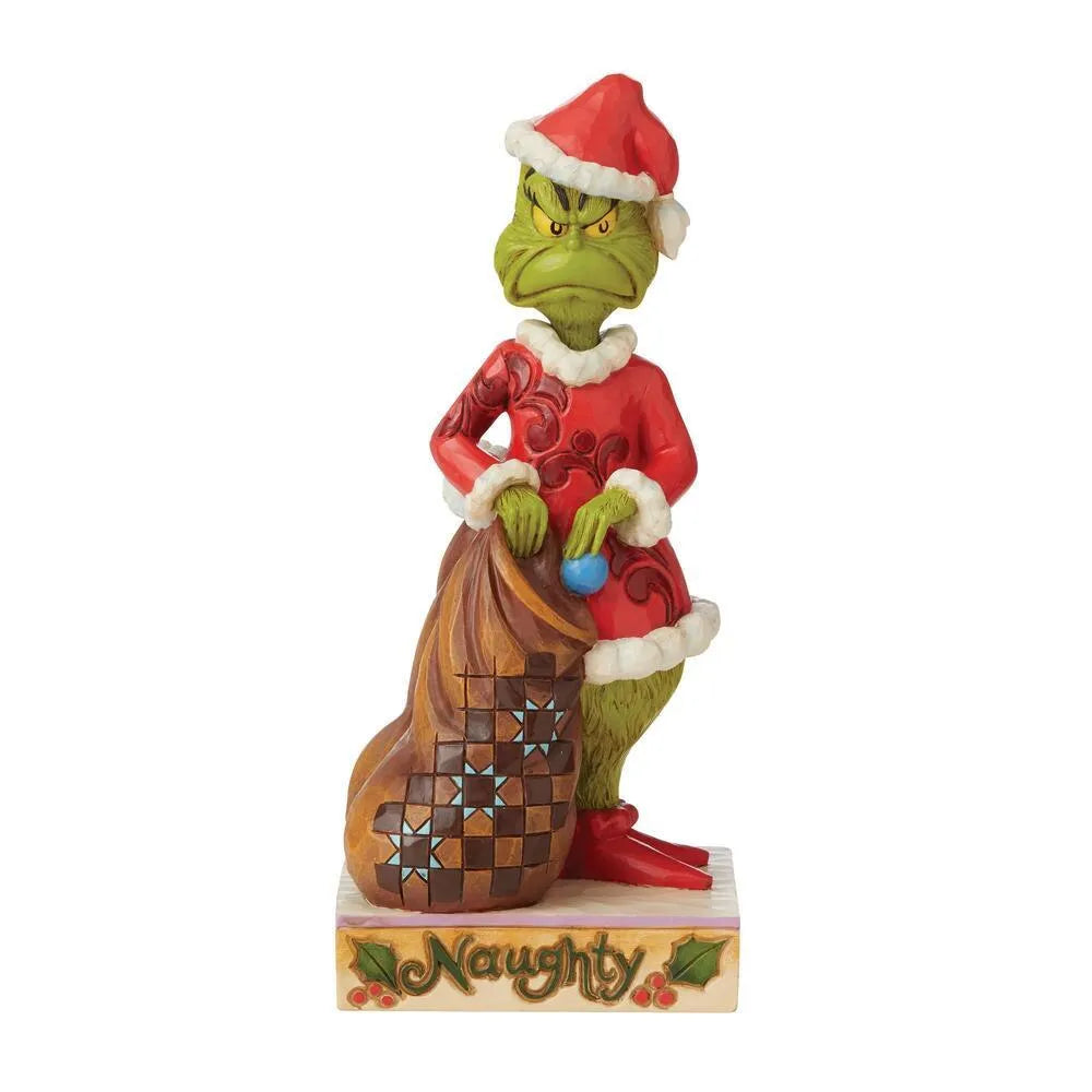 Grinch figurine in red folk art Santa suit leaning on a patchwork sack, "Naughty" inscribed holly base