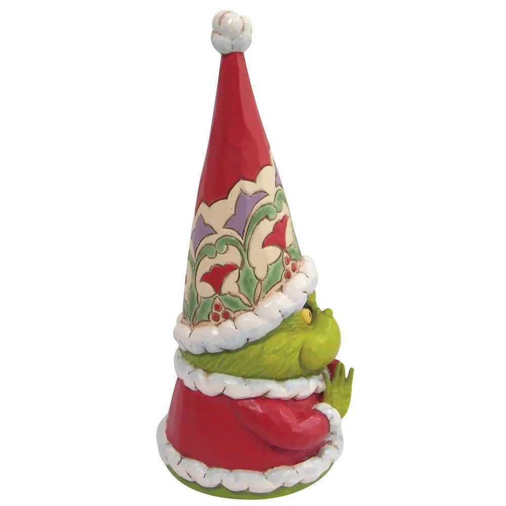 Side view of a Grinch gnome figurine, green face peeking from beneath a tall patterned Santa hat with white fur trim