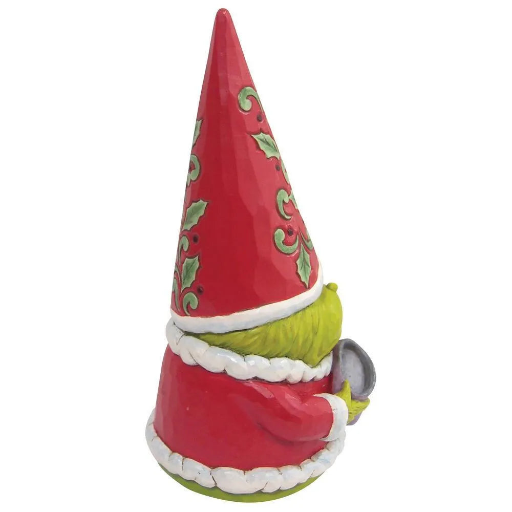 Side view of a Grinch gnome figurine, green face visible beneath a holly-patterned red hat, holding a small cup